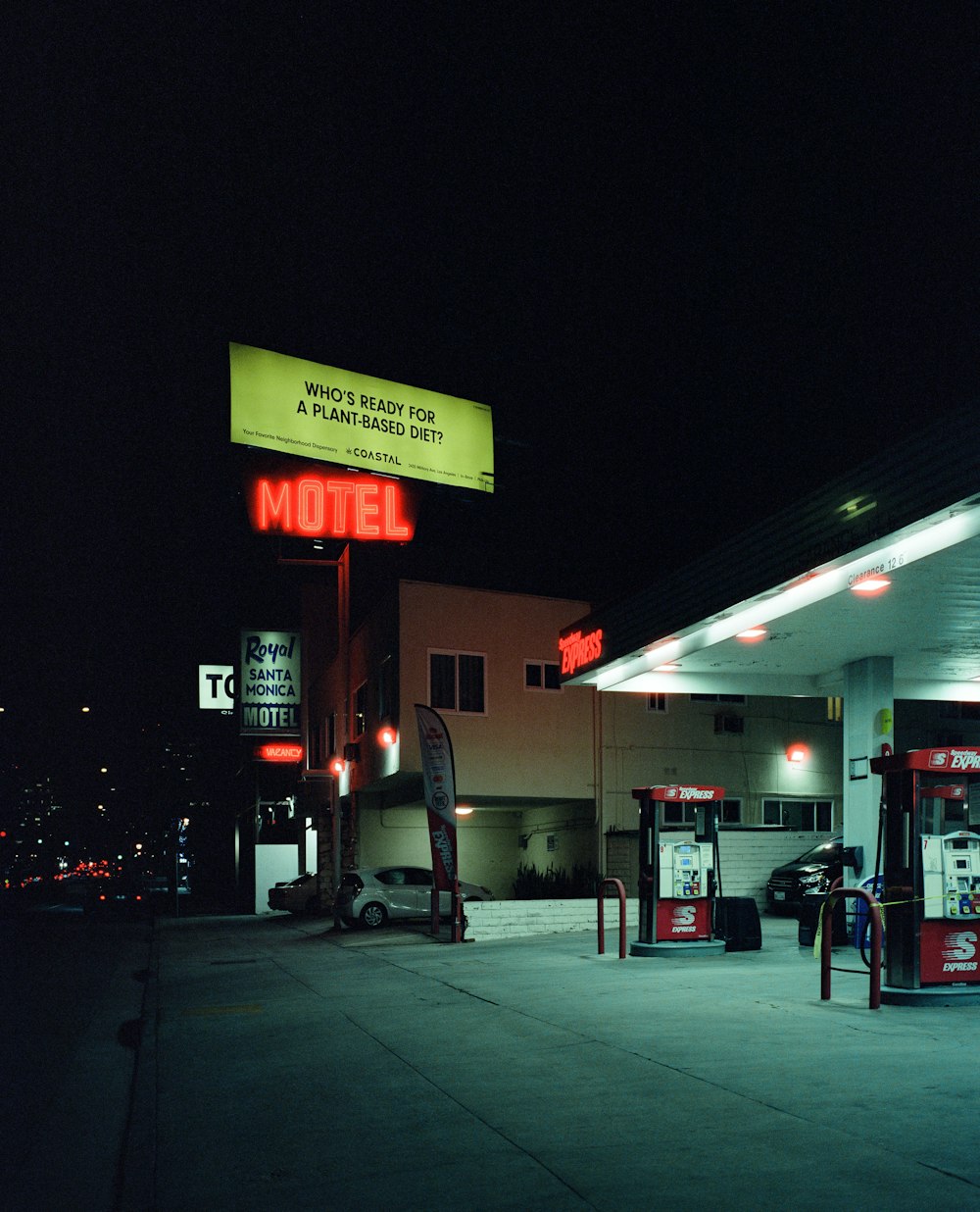 a gas station at night with a neon sign