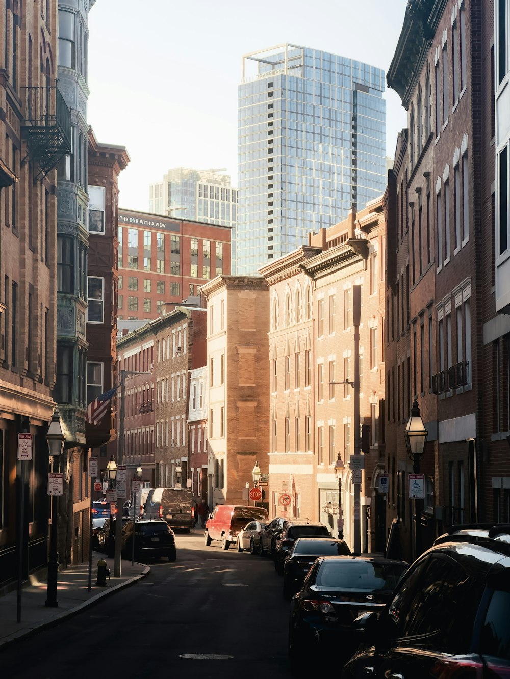 a city street lined with tall buildings and parked cars