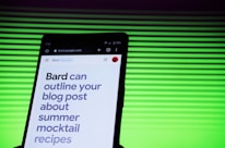 A smartphone screen displaying a webpage with large text about outlining a blog post for summer mocktail recipes. In the background, there is a pattern of horizontal green lines creating a vibrant backdrop.