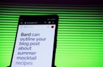 A smartphone screen displaying a webpage with large text about outlining a blog post for summer mocktail recipes. In the background, there is a pattern of horizontal green lines creating a vibrant backdrop.
