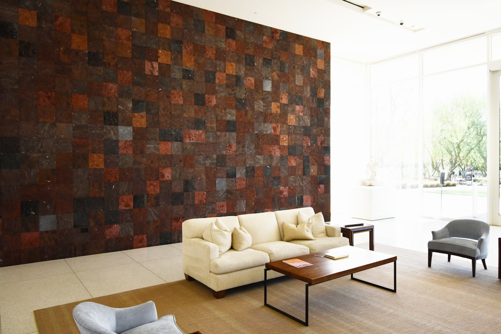 a living room filled with furniture and a large wall