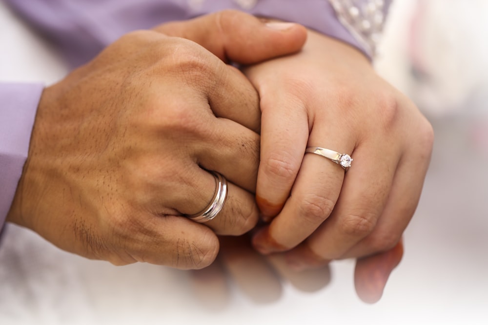 a close up of two people holding hands