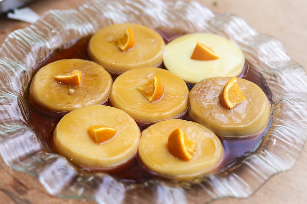 a glass bowl filled with yellow candles on top of a wooden table