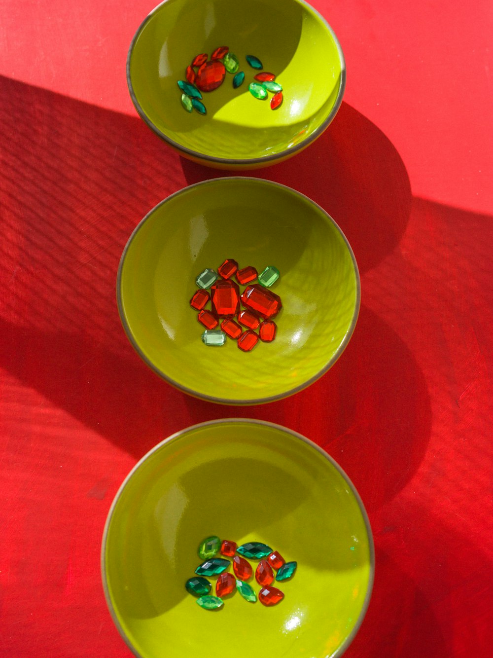 Drei gelbe Schüsseln mit Süßigkeiten darin auf einem roten Tisch