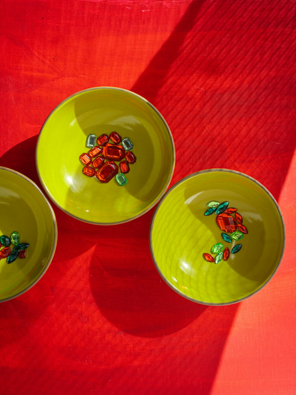 three yellow bowls with designs on them on a red surface