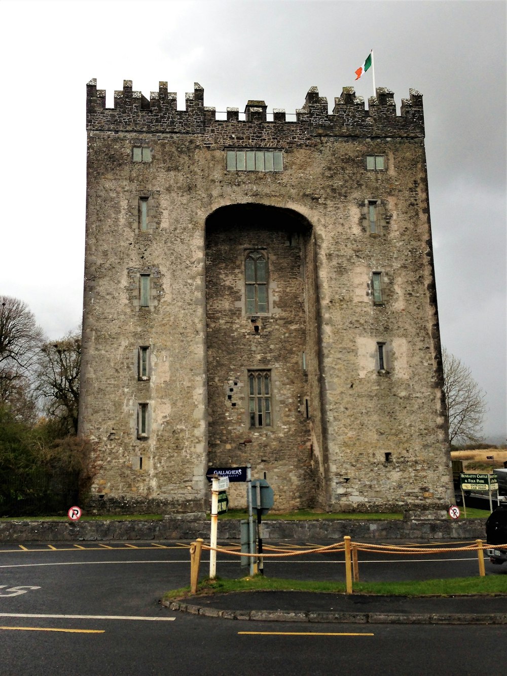 a large stone building with a gate and a flag on top of it