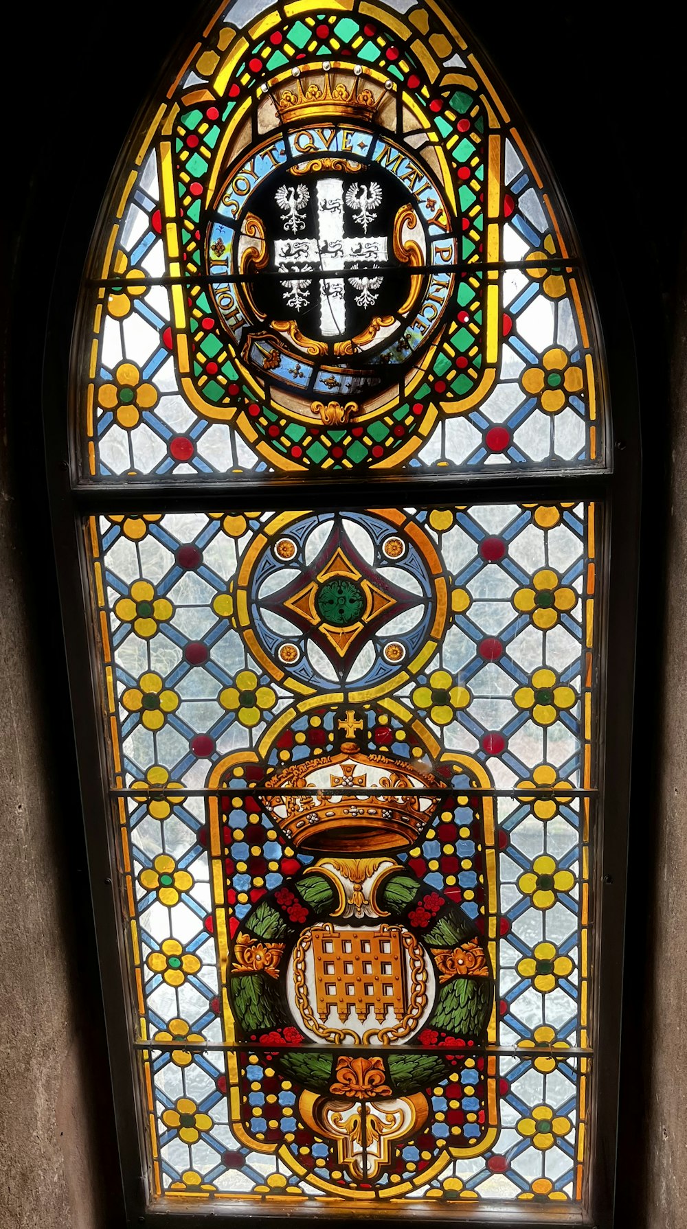 a stained glass window with a coat of arms on it