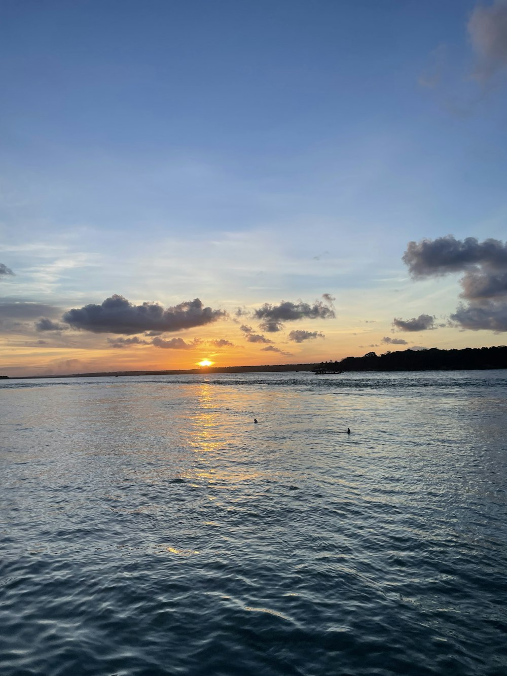 ein Gewässer mit Sonnenuntergang im Hintergrund