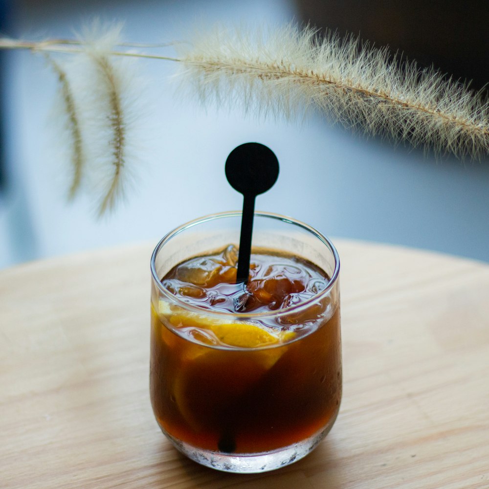 a glass of iced tea with a straw sticking out of it