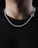 A close-up of a simple silver chain necklace displayed on a wooden surface.