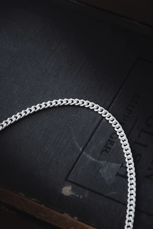 A solid silver chain with a subtle patina, emphasizing its handcrafted quality.