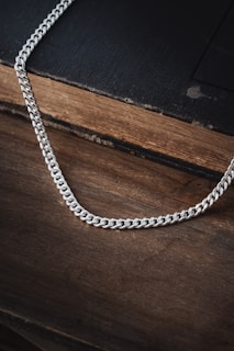 a silver chain on top of a wooden table