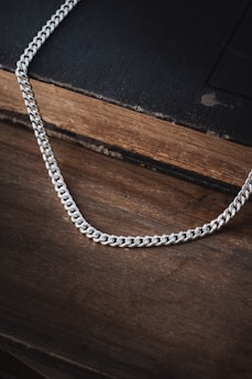 a silver chain on top of a wooden table