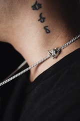 Script tattoo with elegant lettering along collarbone.