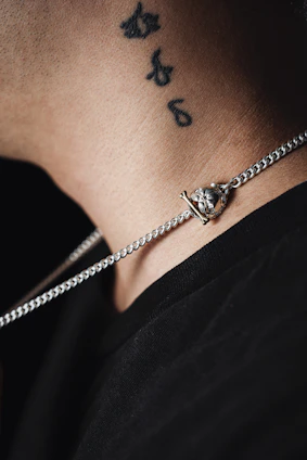 Close-up photo of a silver pendant with a resin-encased keepsake, worn delicately on a woman's collarbone.