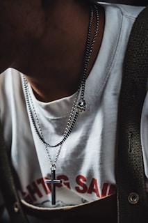 a man wearing a white shirt and a cross necklace
