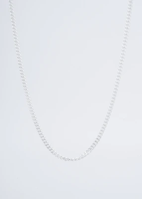 A shiny silver chain necklace elegantly draped over a rustic stone background.