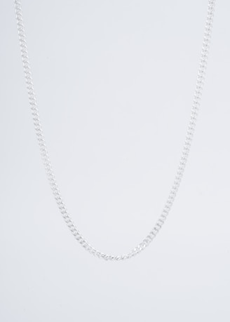 A close-up of a simple metal chain necklace laying on a wooden surface.