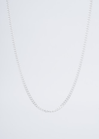Close-up of a sleek black anti-tarnish necklace resting on a minimalist white surface.