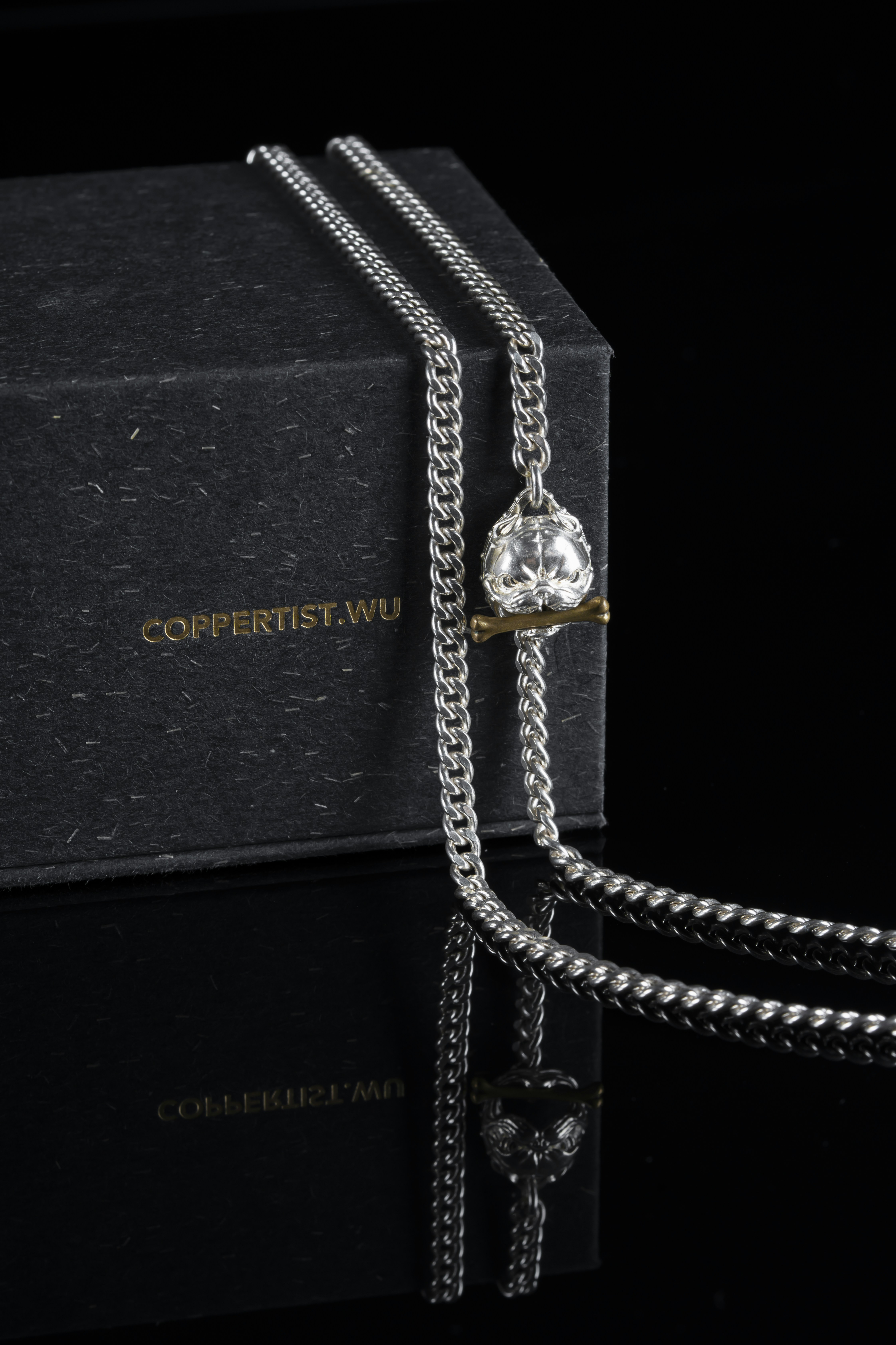 a necklace with a diamond hanging from it