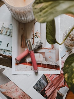 a table topped with pictures and a pink brush