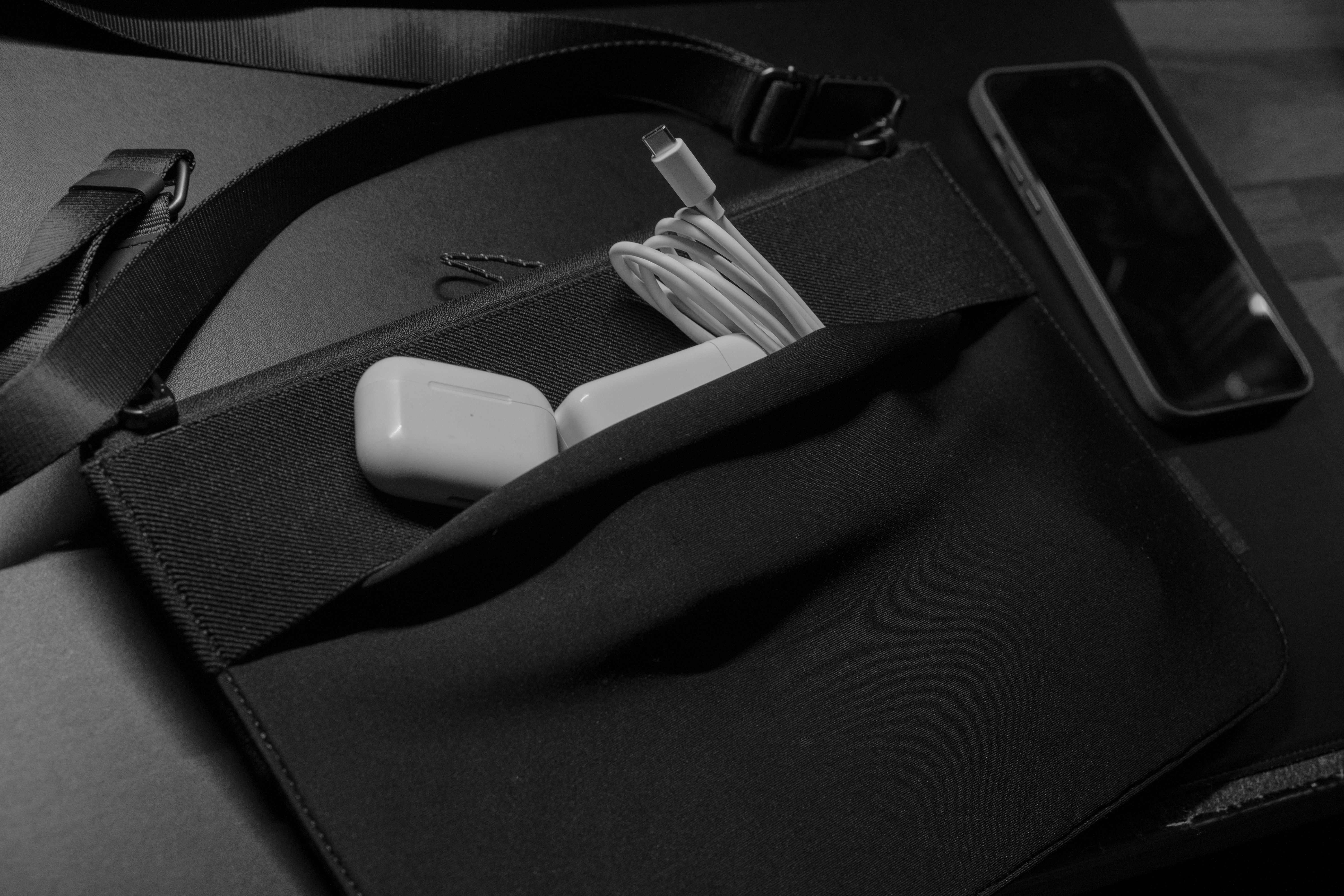 Black gift box containing wireless earbuds, phone stand, and charging cable