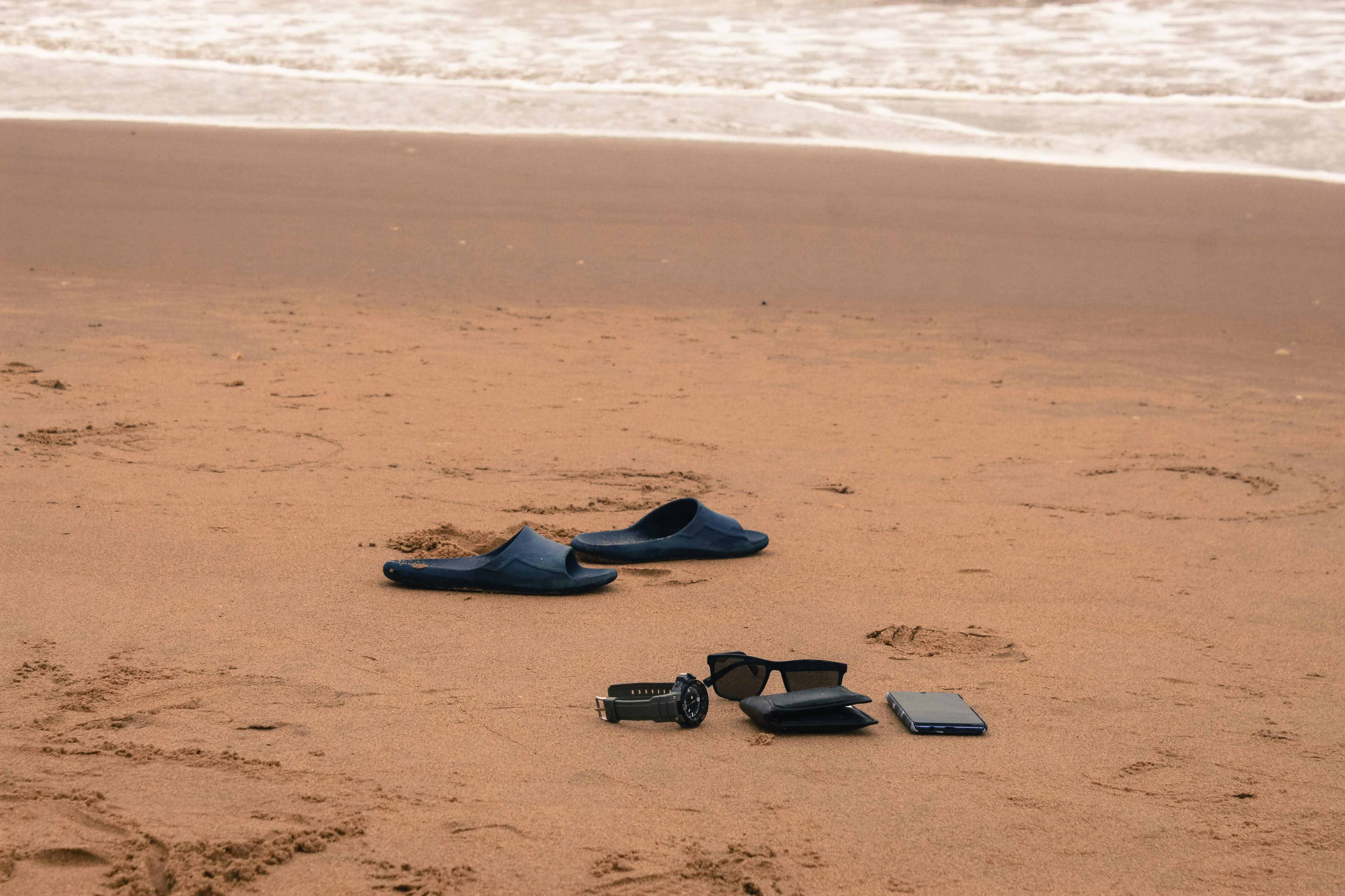 ein Paar Schuhe, die auf einem Sandstrand sitzen