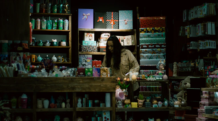 A friendly store clerk helping a customer choose from a colorful display of electric gadgets.