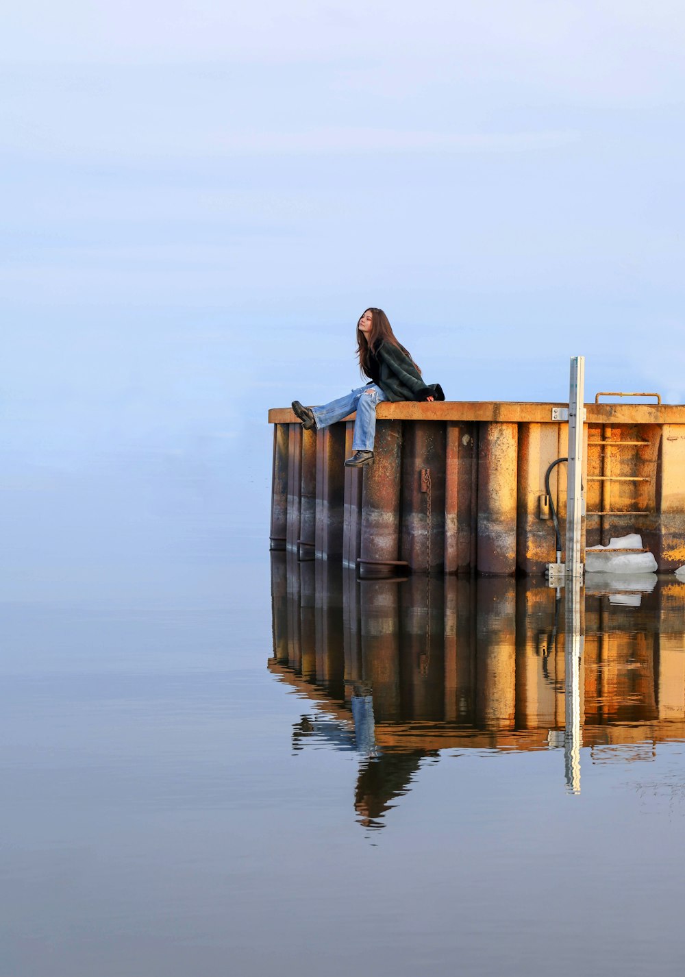 a woman sitting on top of a wooden dock