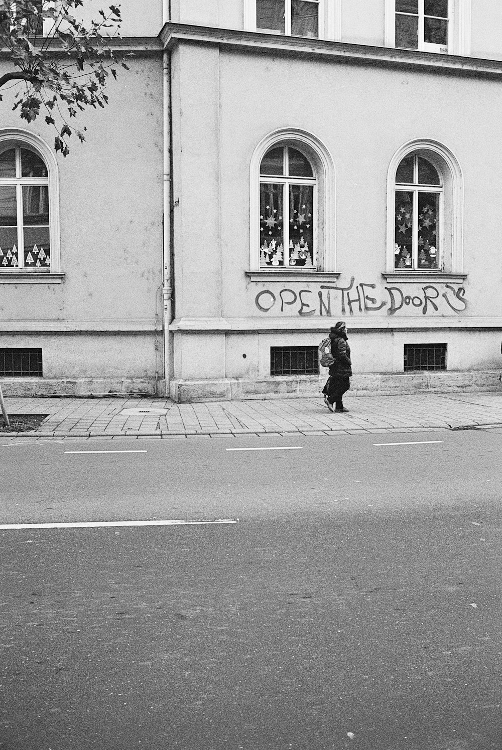 Una foto in bianco e nero di una donna che cammina per strada