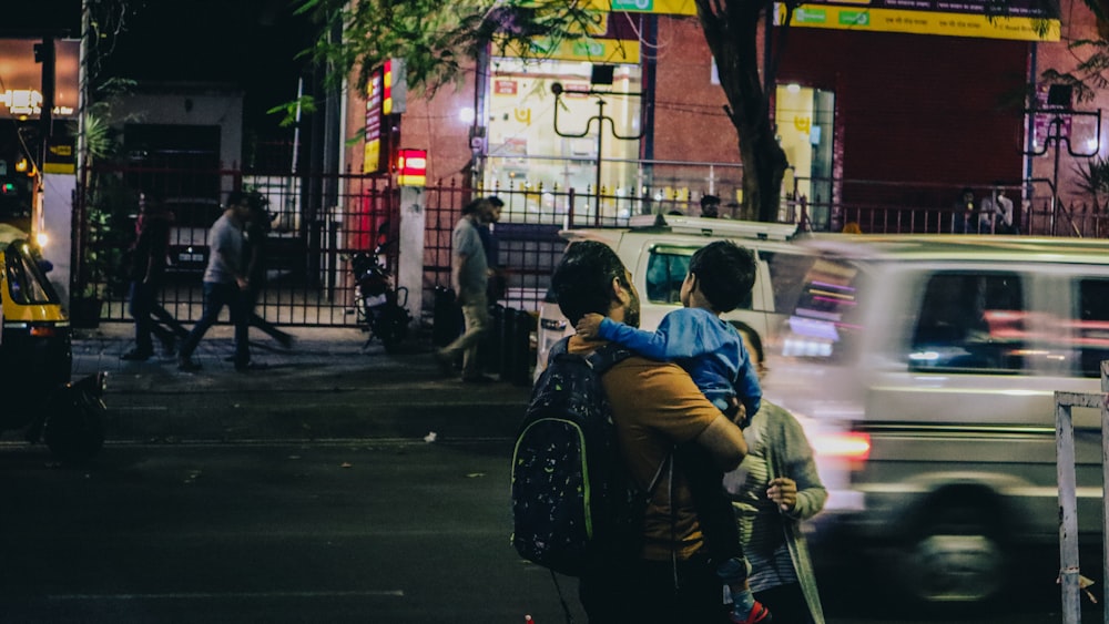 a couple of people walking down a street at night