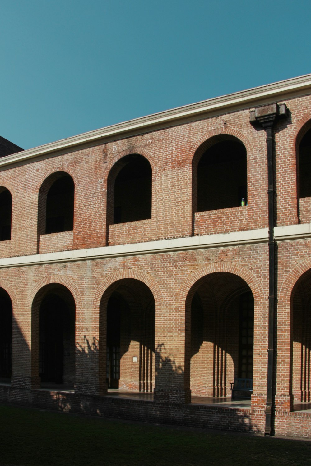 a brick building with arches and a clock on the side of it