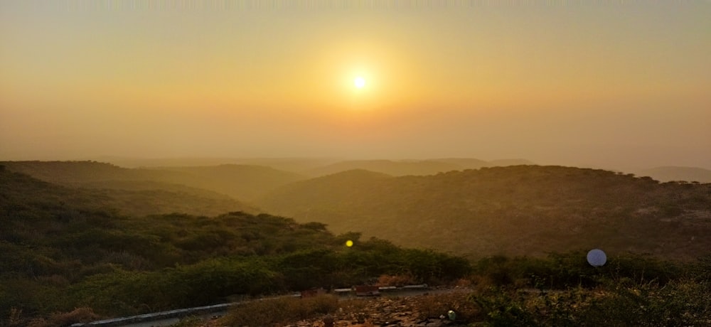 the sun is setting over a mountain range