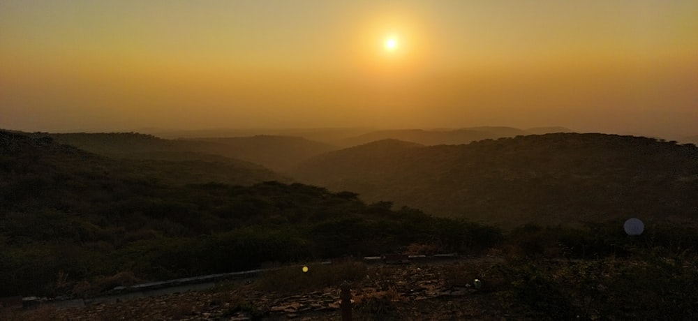 the sun is setting over a mountain range