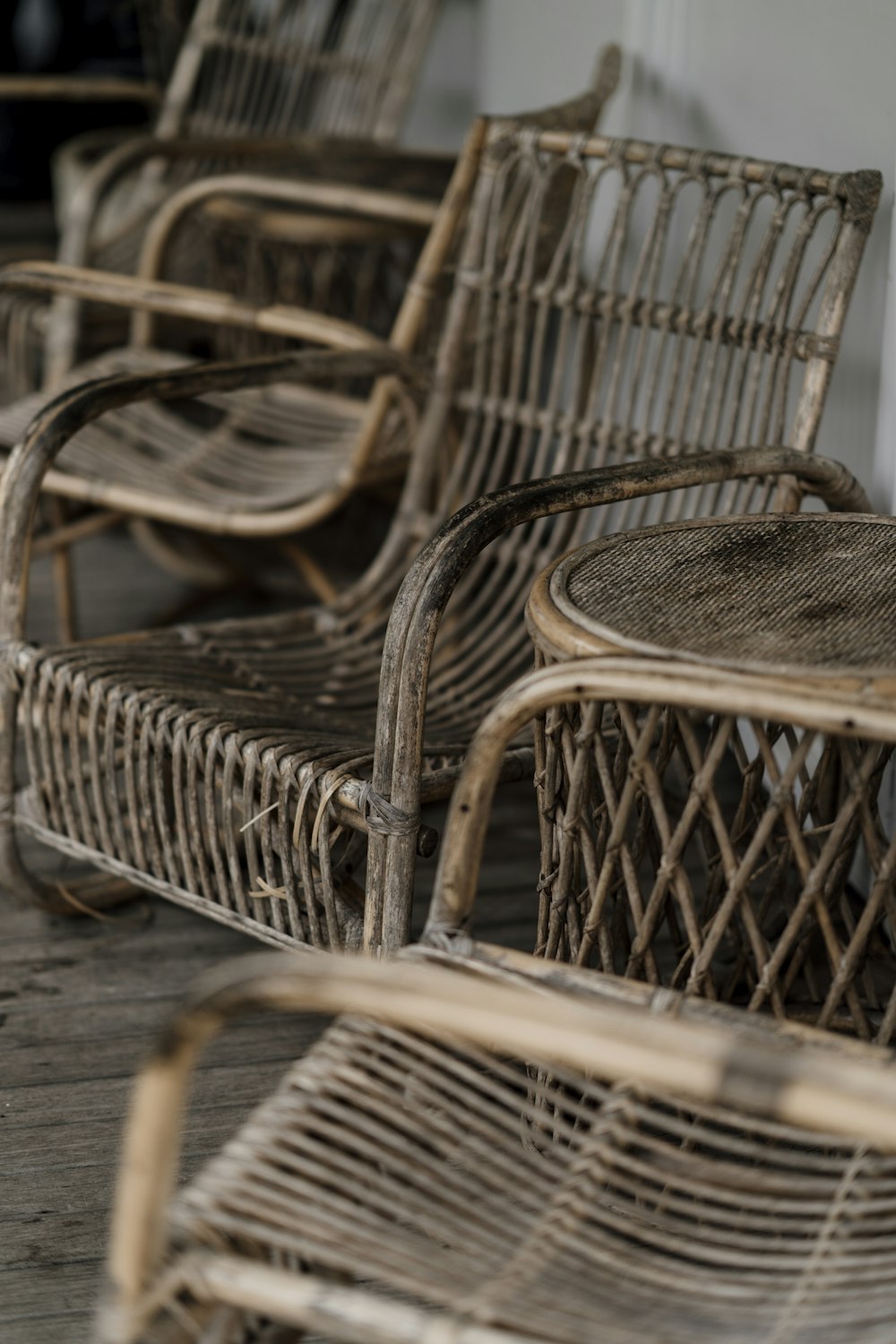 a row of wicker chairs sitting on top of a wooden floor