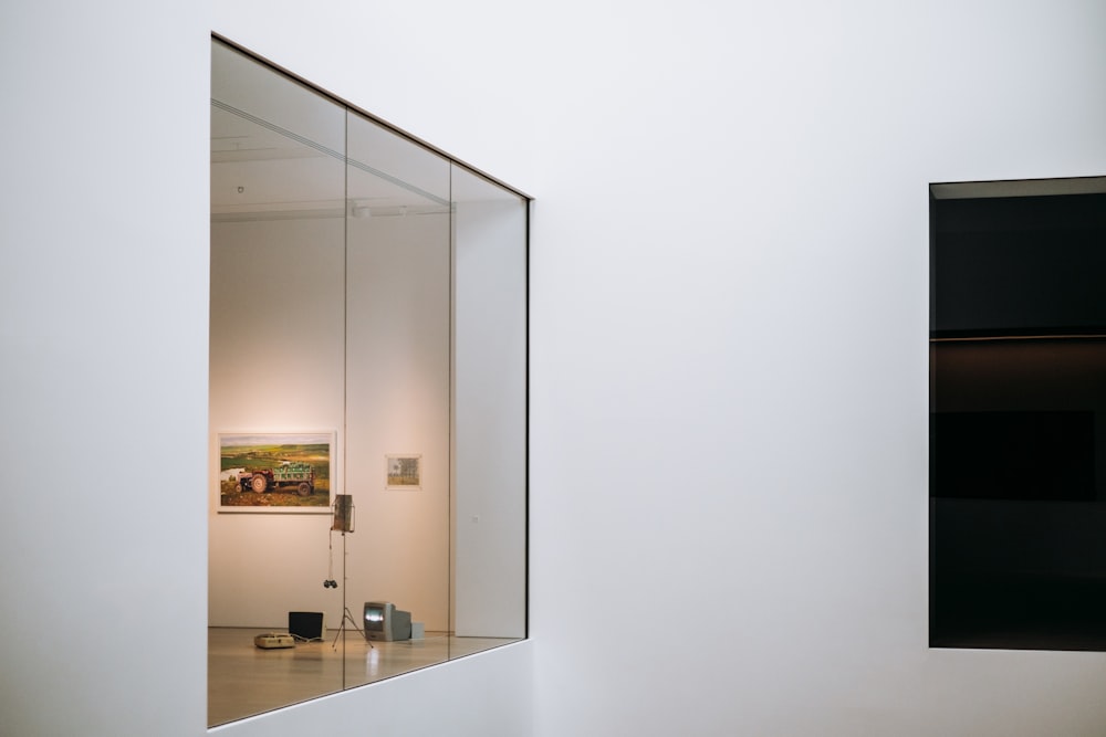 a white room with a mirror and a painting on the wall