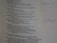 A close-up view of a page from a book or document with text printed on it. The text appears to be from a religious or philosophical book, possibly a Bible. Some handwritten notes are visible on the right side of the page, written on lined paper.