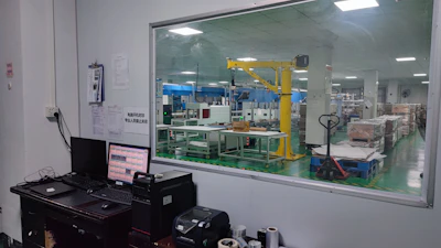 Technician programming an automated system in a factory environment with clear focus and rounded image borders.
