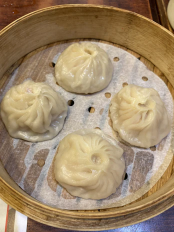 Delicate dim sum baskets filled with steamed pork dumplings, glistening with a hint of soy.