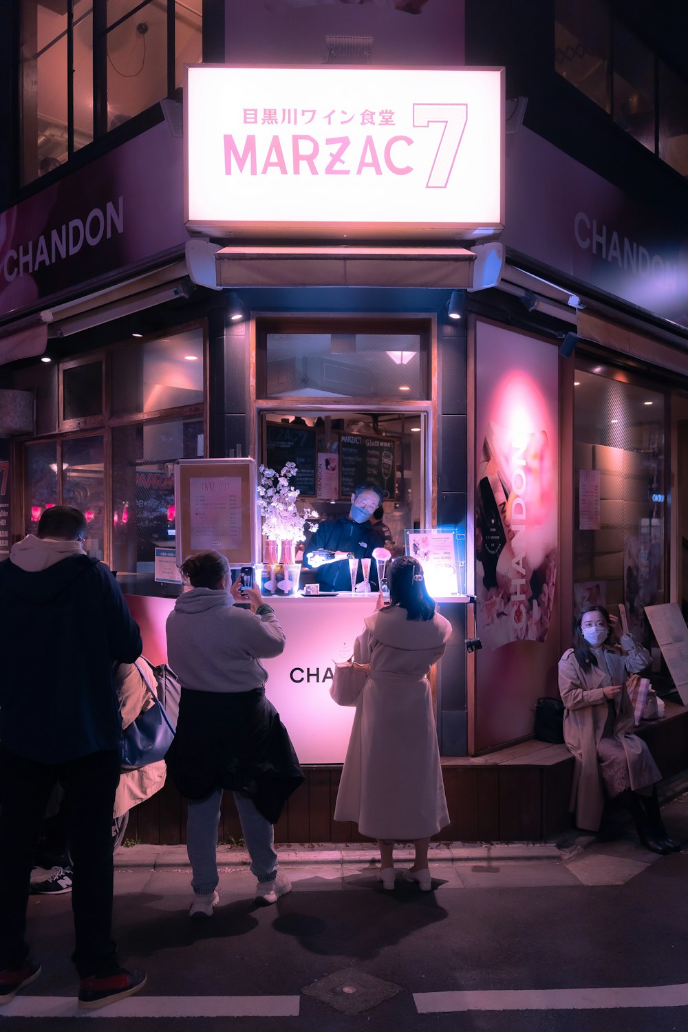 un groupe de personnes debout à l’extérieur d’un magasin