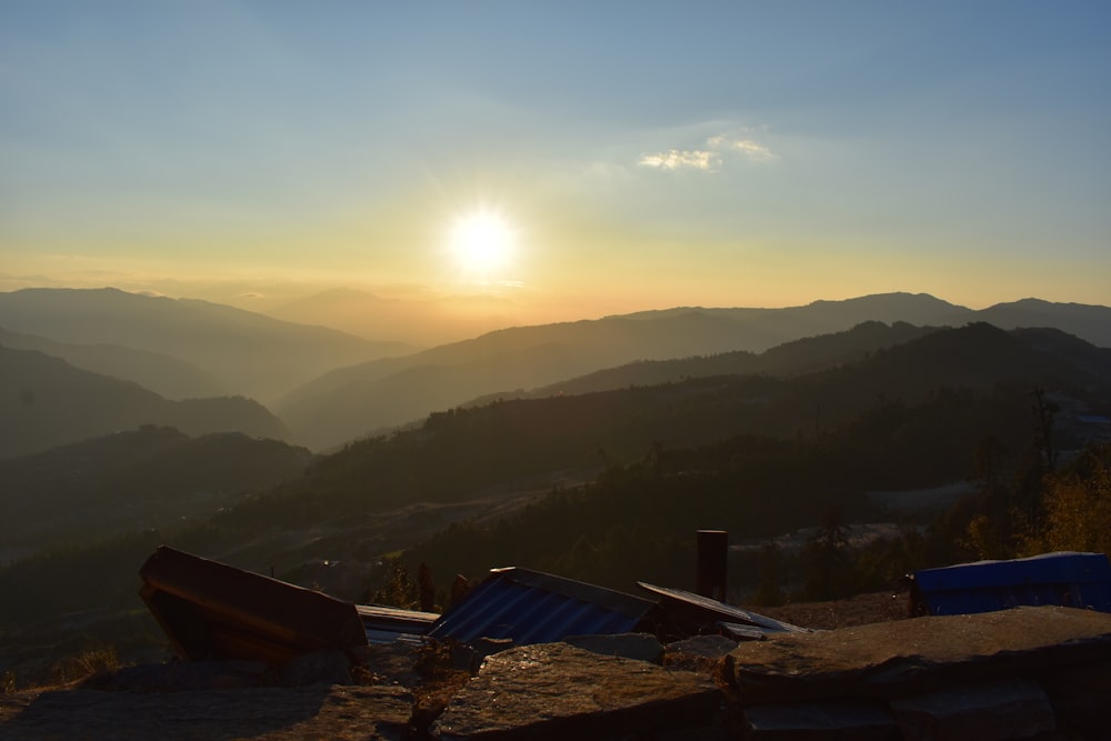 the sun is setting over a mountain range