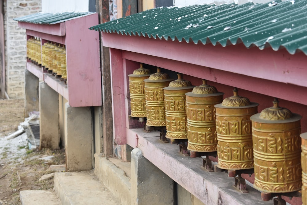 a row of gold bells sitting on the side of a building