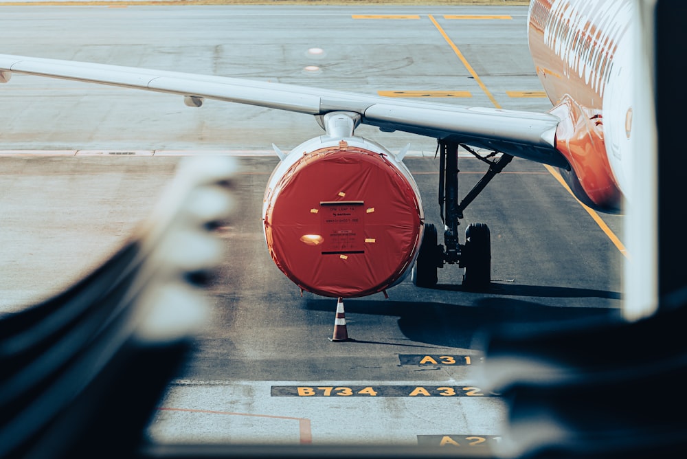 a red and white airplane is parked on the runway