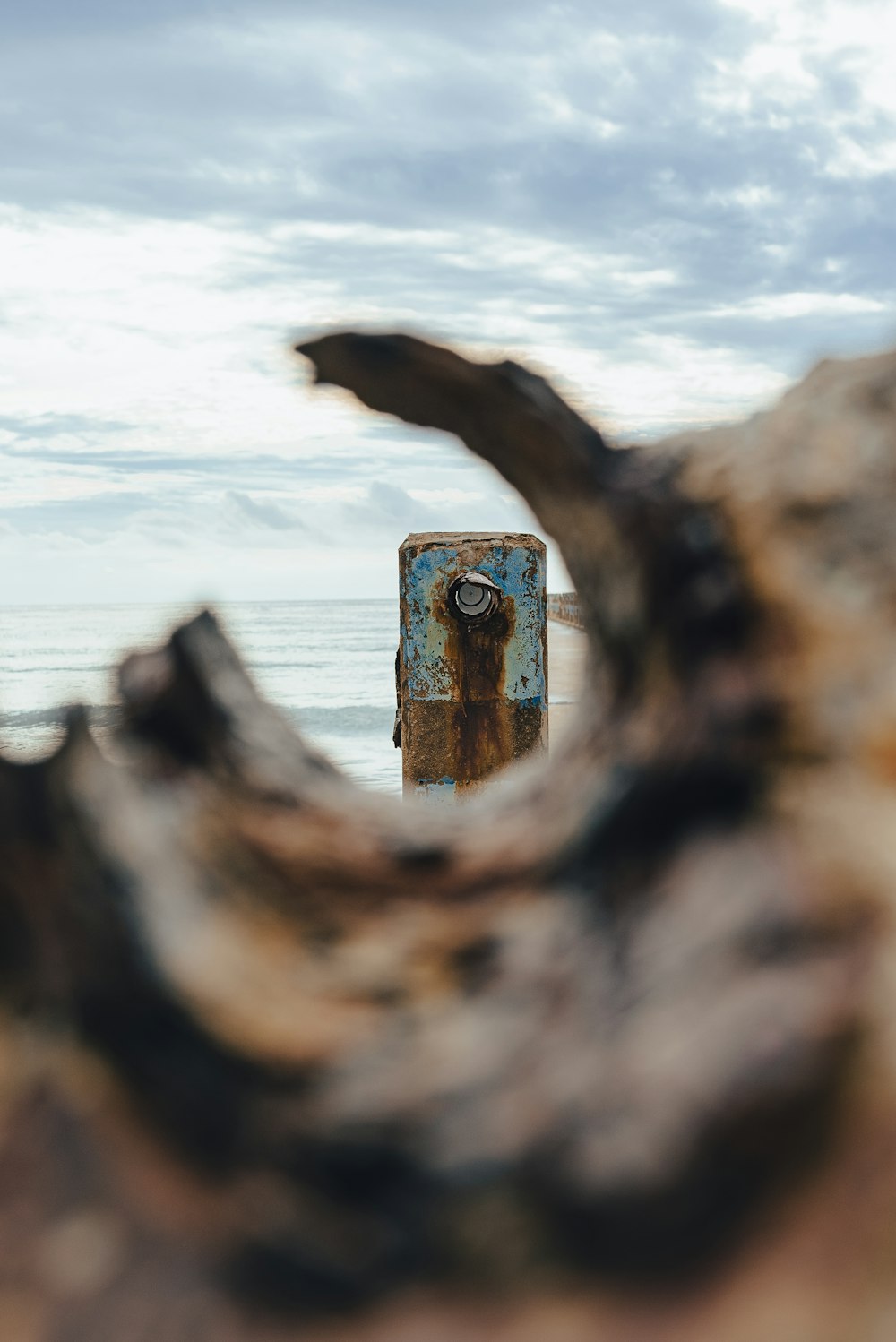 un objet métallique rouillé assis au sommet d’une plage