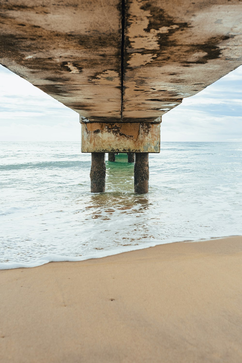 the underside of a wooden structure on the beach