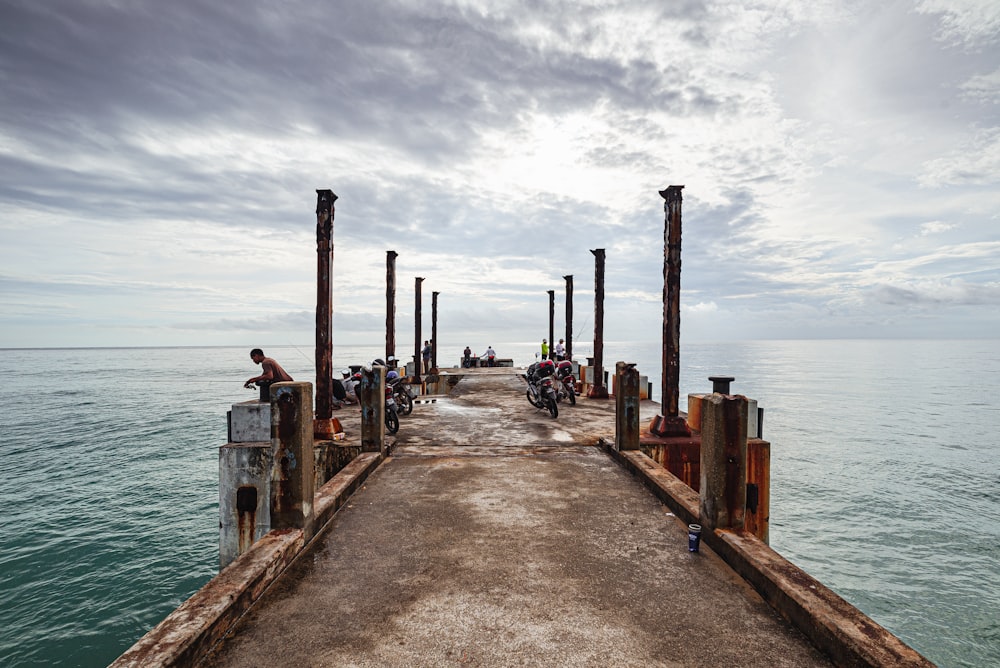 a group of people riding motorcycles on top of a pier