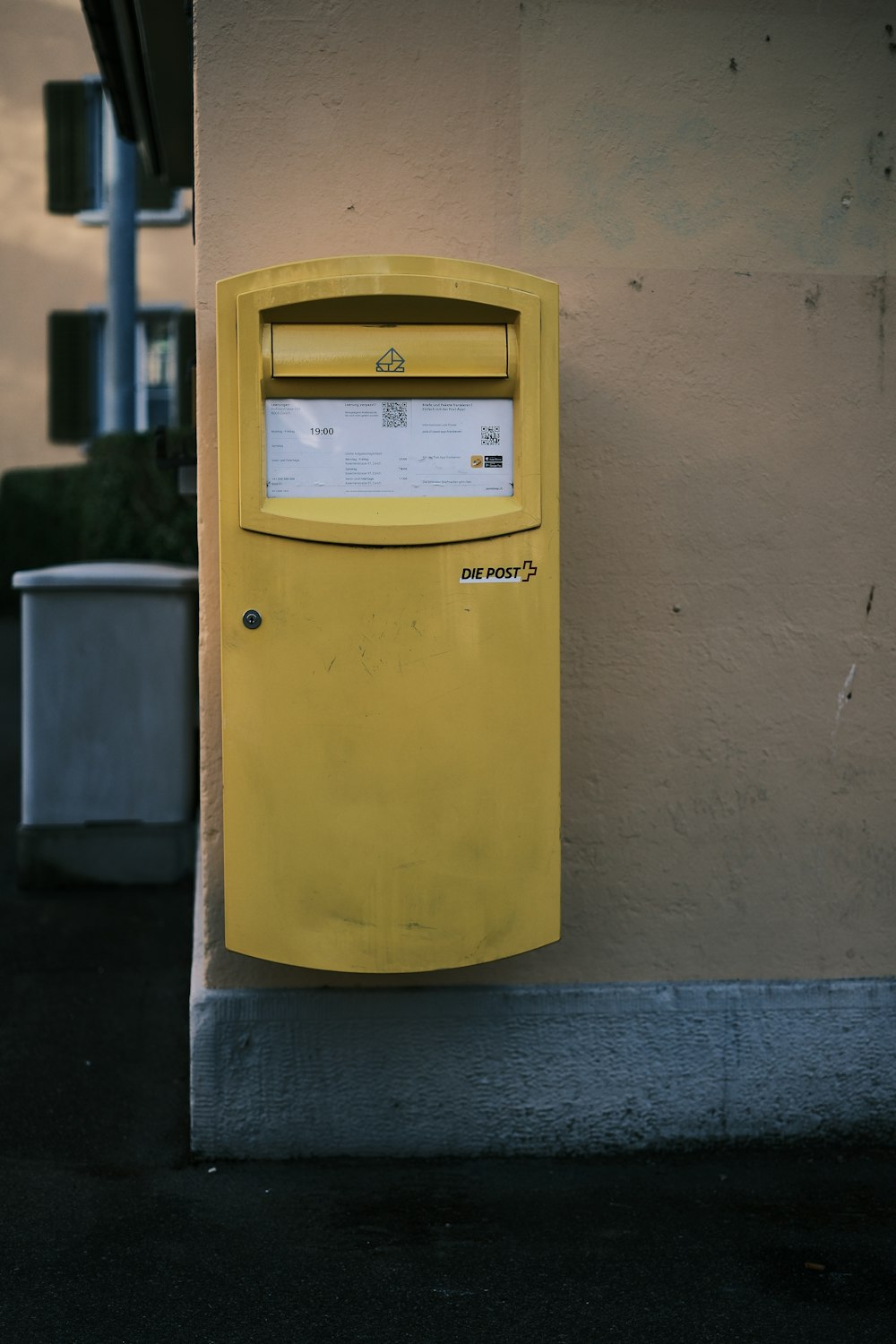 a yellow mailbox on the side of a building