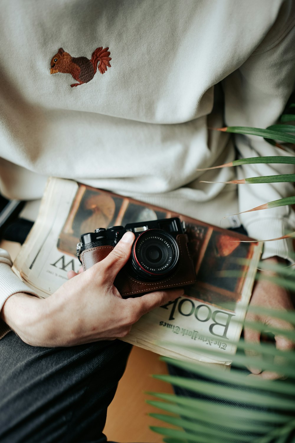 a person holding a camera and a book