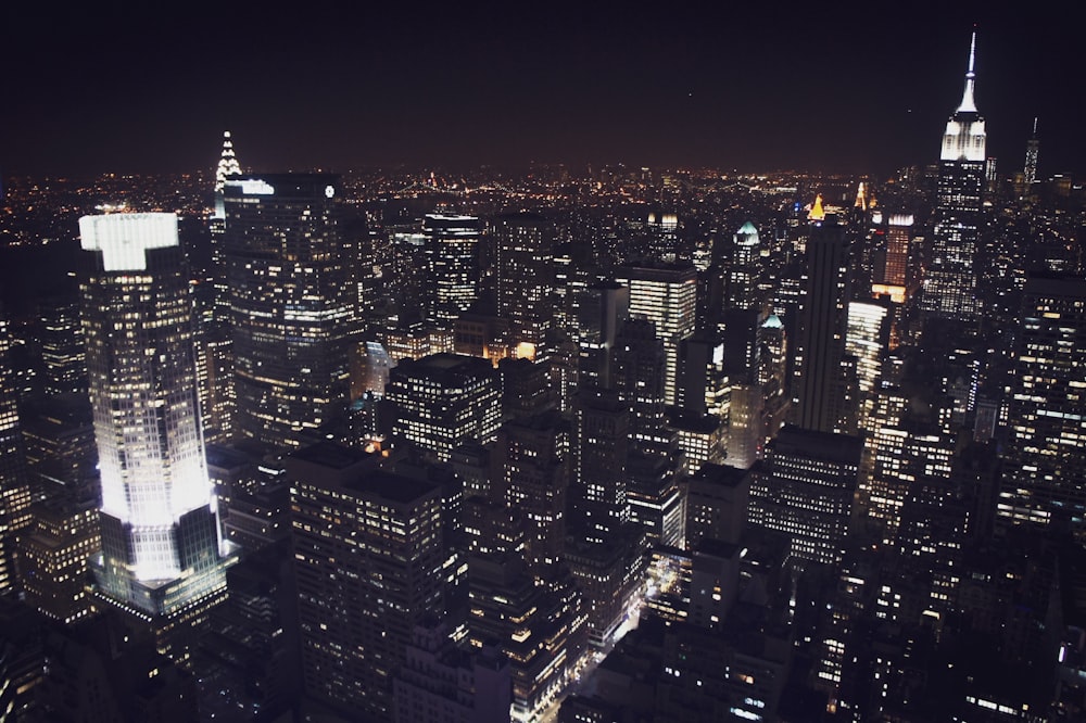 a view of a city at night from the top of a skyscraper