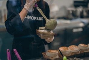 Hands carefully packing fresh dosa batter into hygienic containers.